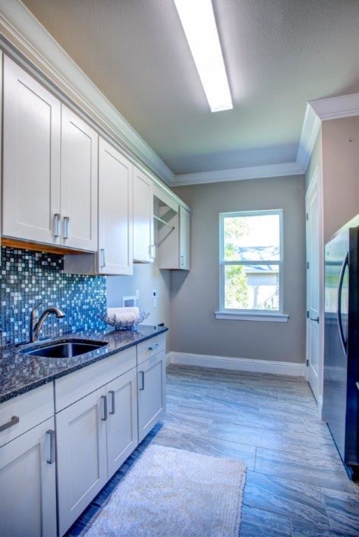 Inspiration for a mid-sized transitional galley porcelain tile utility room remodel in Orlando with a drop-in sink, white cabinets, quartz countertops, gray walls and a side-by-side washer/dryer
