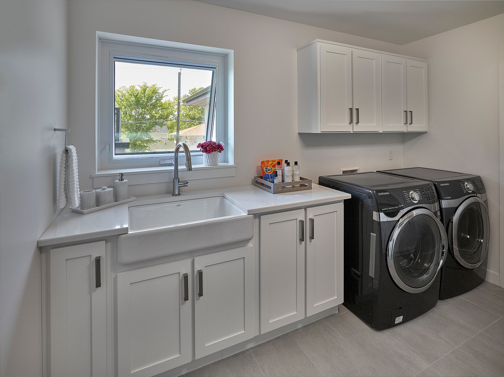 Diseño de cuarto de lavado lineal contemporáneo de tamaño medio con fregadero sobremueble, armarios estilo shaker, puertas de armario blancas, encimera de acrílico, paredes blancas y lavadora y secadora juntas