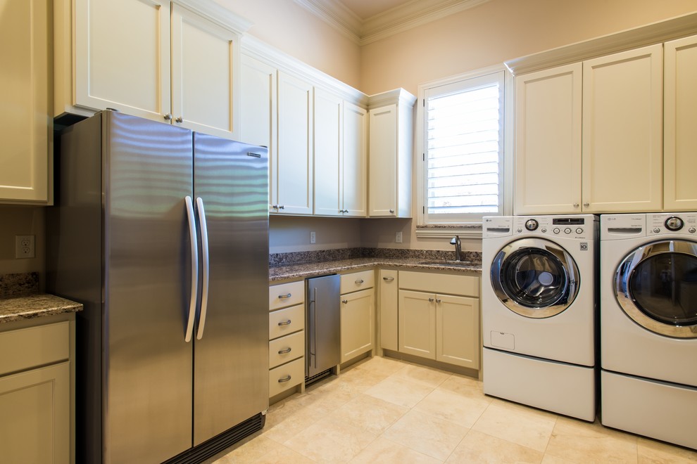 Example of a large trendy l-shaped ceramic tile dedicated laundry room design in Dallas with an undermount sink, shaker cabinets, white cabinets, granite countertops, beige walls and a side-by-side washer/dryer