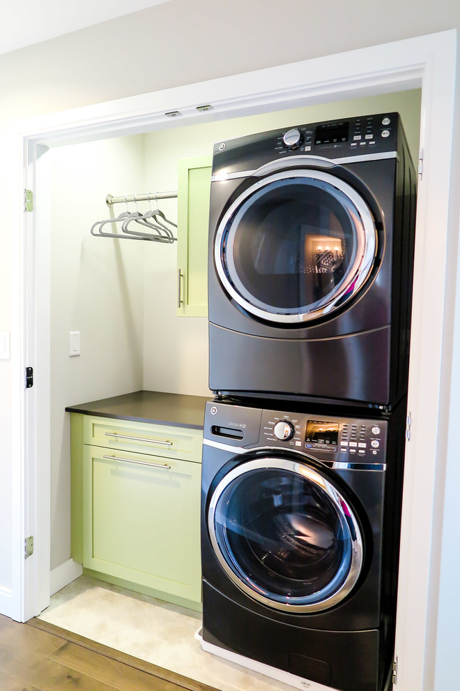 Idee per una lavanderia moderna con top in granito, parquet chiaro e lavatrice e asciugatrice a colonna