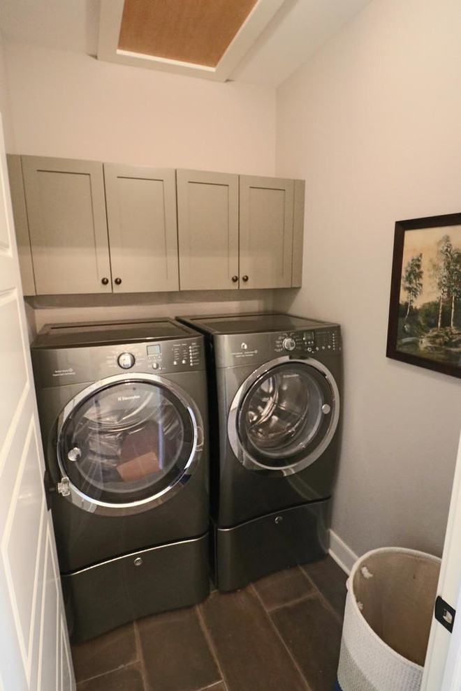 Imagen de cuarto de lavado lineal de estilo de casa de campo pequeño con armarios con paneles empotrados, puertas de armario verdes, paredes beige, suelo de baldosas de porcelana y lavadora y secadora juntas