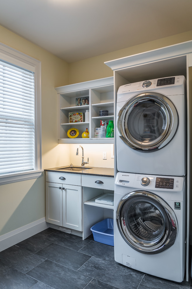 Medium sized nautical single-wall utility room in Toronto with a submerged sink, shaker cabinets, white cabinets, granite worktops, beige walls, slate flooring and a stacked washer and dryer.