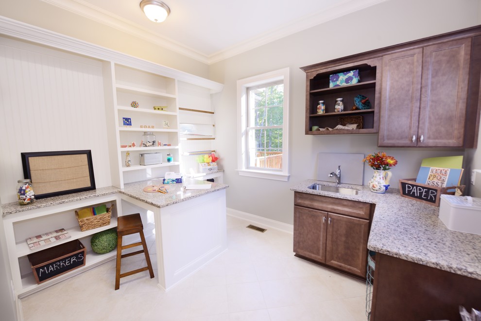Inspiration for a timeless l-shaped utility room remodel in Raleigh with medium tone wood cabinets, granite countertops, beige walls and a side-by-side washer/dryer