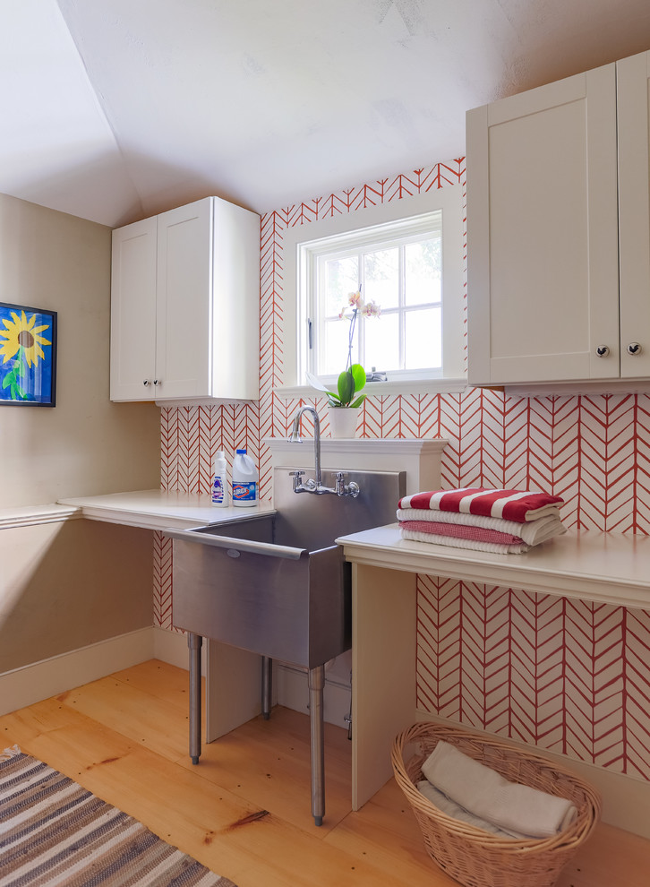 Einzeilige, Kleine Landhausstil Waschküche mit Ausgussbecken, weißen Schränken, Schrankfronten im Shaker-Stil, bunten Wänden und braunem Holzboden in Boston