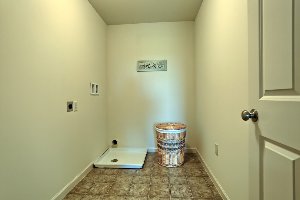 Photo of a large classic separated utility room in Other with vinyl flooring and a side by side washer and dryer.