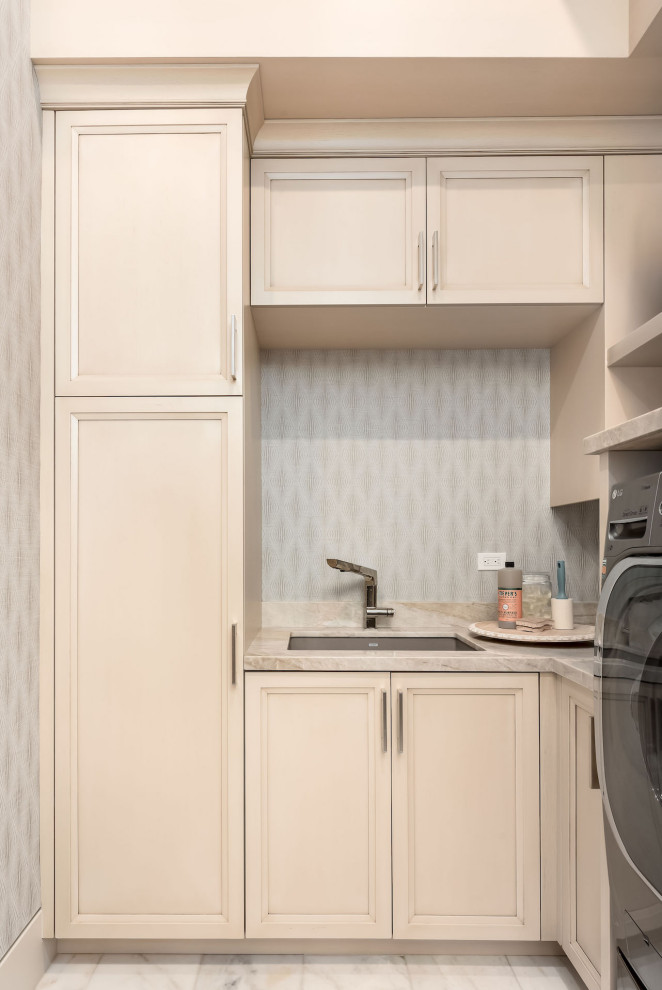 Exempel på en modern u-formad tvättstuga, med en nedsänkt diskho, grå väggar och en tvättmaskin och torktumlare bredvid varandra