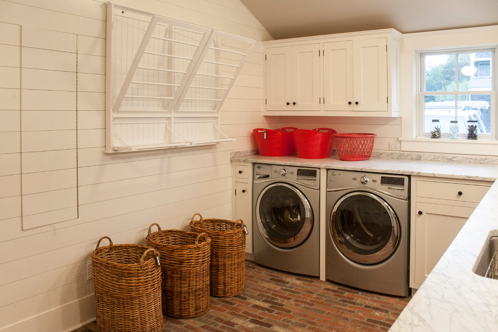 Design ideas for a large coastal l-shaped separated utility room in New York with a submerged sink, shaker cabinets, white cabinets, white walls, brick flooring and a side by side washer and dryer.