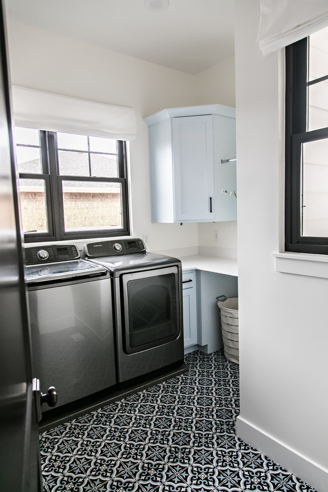Kleine Country Waschküche in L-Form mit Schrankfronten im Shaker-Stil, weißen Schränken, Quarzwerkstein-Arbeitsplatte, weißer Wandfarbe, Waschmaschine und Trockner nebeneinander, buntem Boden und weißer Arbeitsplatte in Salt Lake City