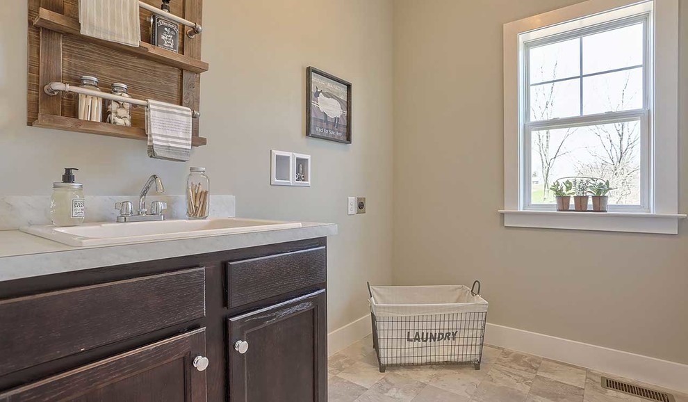 Example of a mid-sized mountain style galley laminate floor and beige floor laundry closet design in Other with an utility sink, dark wood cabinets, laminate countertops, gray walls, a side-by-side washer/dryer and beige countertops