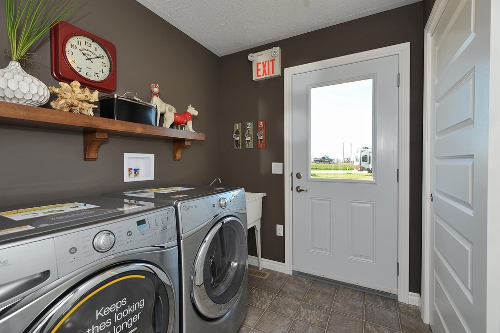 Modelo de cuarto de lavado de galera clásico con pila para lavar, paredes grises, suelo vinílico, lavadora y secadora juntas y suelo gris