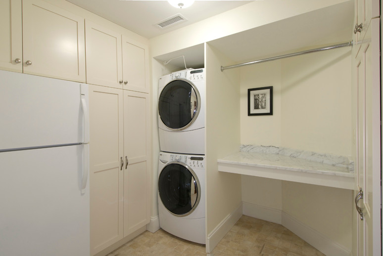 Ejemplo de lavadero moderno grande con armarios con paneles empotrados, puertas de armario beige, encimera de mármol, paredes beige y lavadora y secadora apiladas