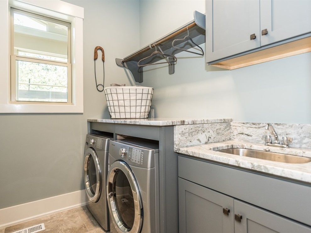 Idéer för amerikanska linjära tvättstugor enbart för tvätt, med en undermonterad diskho, skåp i shakerstil, grå skåp, granitbänkskiva, gröna väggar, klinkergolv i keramik och en tvättmaskin och torktumlare bredvid varandra