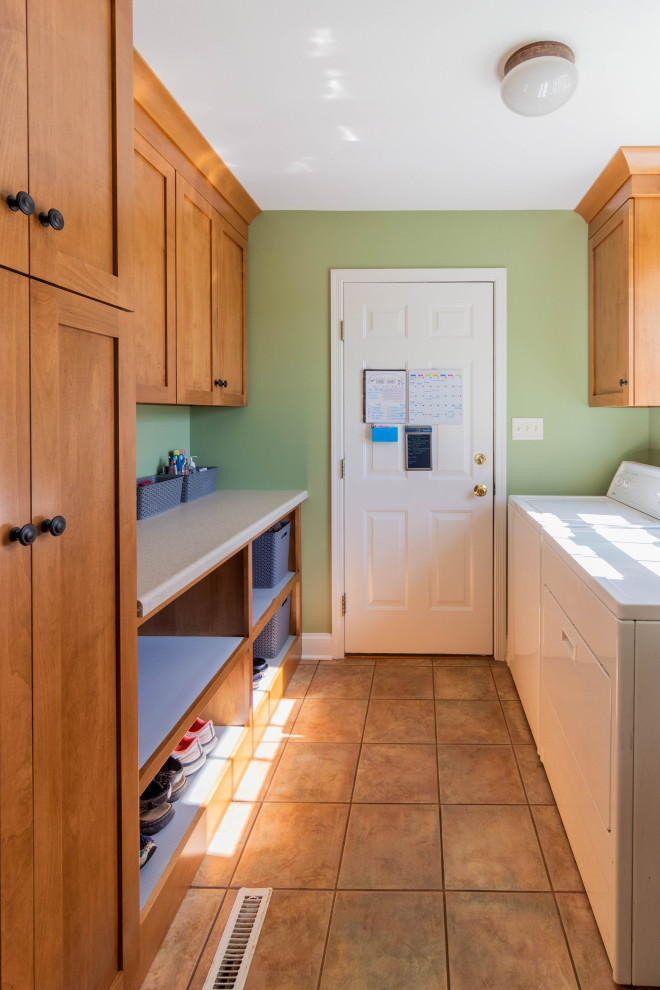 他の地域にあるお手頃価格の小さなトラディショナルスタイルのおしゃれな家事室 (ll型、シングルシンク、シェーカースタイル扉のキャビネット、中間色木目調キャビネット、ラミネートカウンター、緑の壁、磁器タイルの床、左右配置の洗濯機・乾燥機、ベージュの床、ベージュのキッチンカウンター) の写真