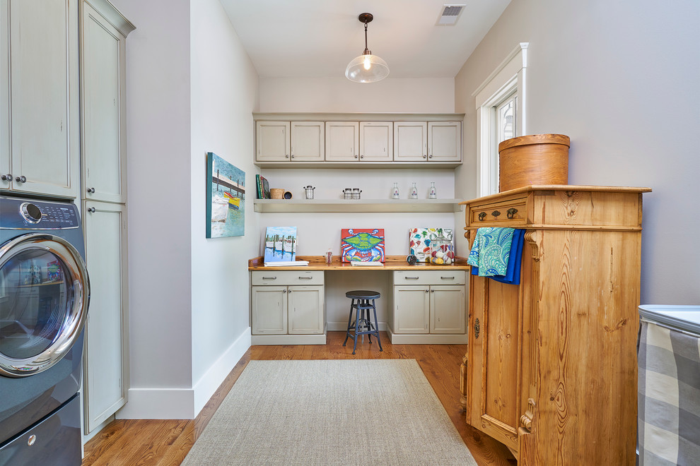 Large traditional galley utility room in Charleston with an utility sink, grey cabinets, wood worktops, grey walls, medium hardwood flooring, a side by side washer and dryer and recessed-panel cabinets.