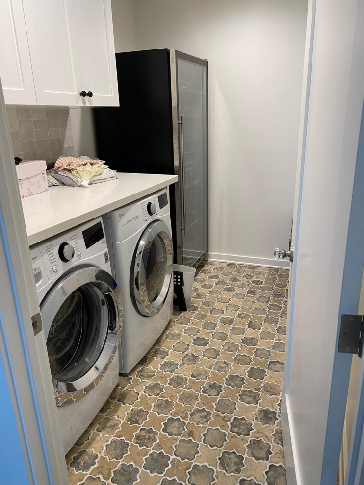 Immagine di un ripostiglio-lavanderia minimalista di medie dimensioni con pavimento marrone