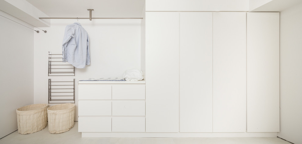 Example of a minimalist laundry room design in Philadelphia with flat-panel cabinets, white cabinets, white walls and a side-by-side washer/dryer