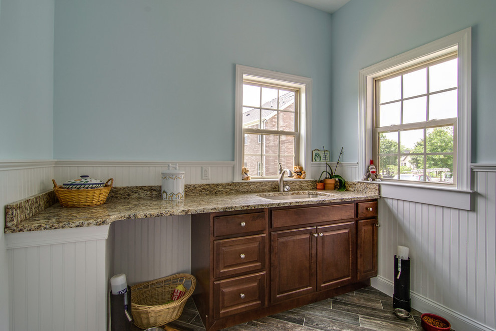 Multifunktionaler, Einzeiliger, Mittelgroßer Klassischer Hauswirtschaftsraum mit Unterbauwaschbecken, profilierten Schrankfronten, dunklen Holzschränken, Granit-Arbeitsplatte, blauer Wandfarbe und Keramikboden in Nashville