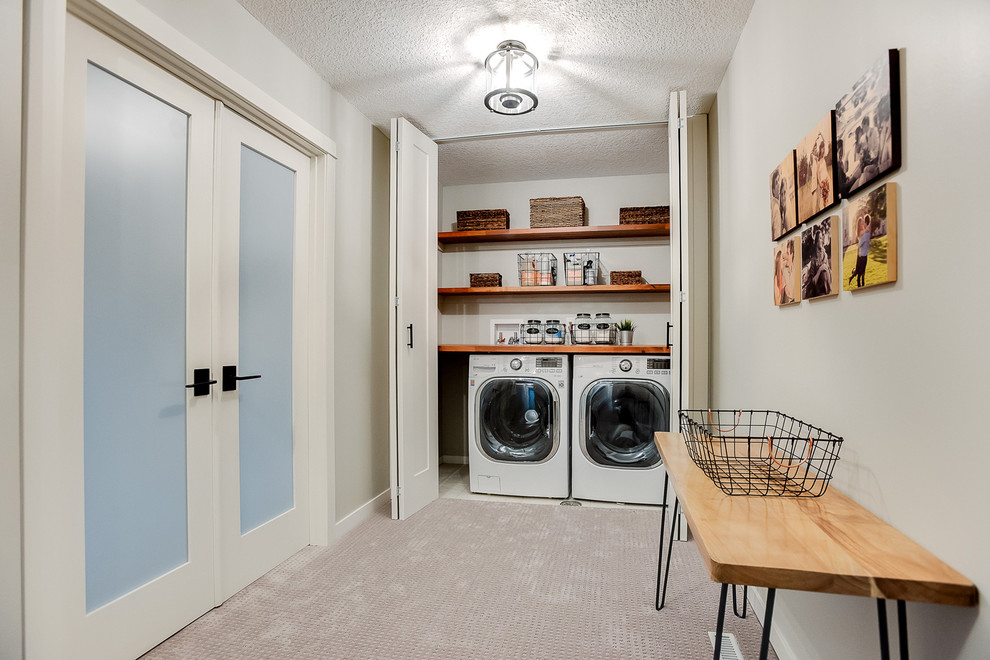 Immagine di una lavanderia tradizionale di medie dimensioni con pareti beige, parquet scuro e pavimento beige