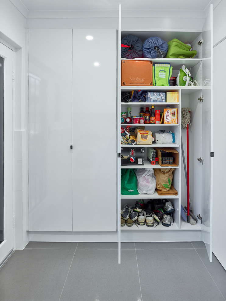 Ejemplo de cuarto de lavado lineal contemporáneo de tamaño medio con fregadero encastrado, puertas de armario blancas, encimera de laminado, paredes blancas y lavadora y secadora juntas