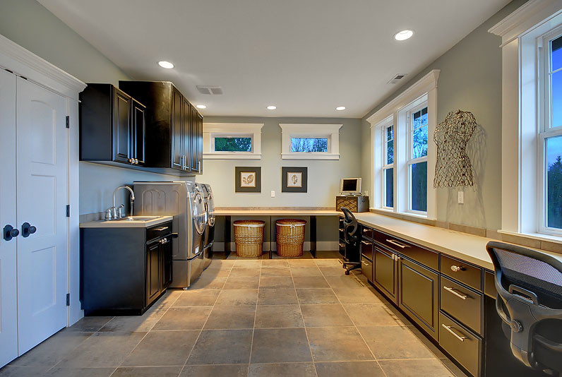 This is an example of a traditional utility room in Seattle with recessed-panel cabinets, black cabinets, laminate countertops, porcelain flooring and grey floors.