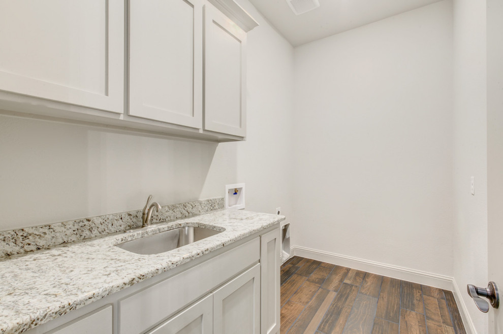 This is an example of a medium sized classic separated utility room in Dallas with a submerged sink, shaker cabinets, white cabinets, white walls, dark hardwood flooring, brown floors, grey worktops, granite worktops and a side by side washer and dryer.