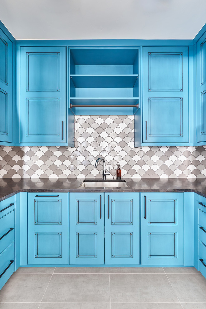 Immagine di una grande sala lavanderia contemporanea con lavello sottopiano, ante blu, pareti grigie, pavimento con piastrelle in ceramica, pavimento grigio e top nero