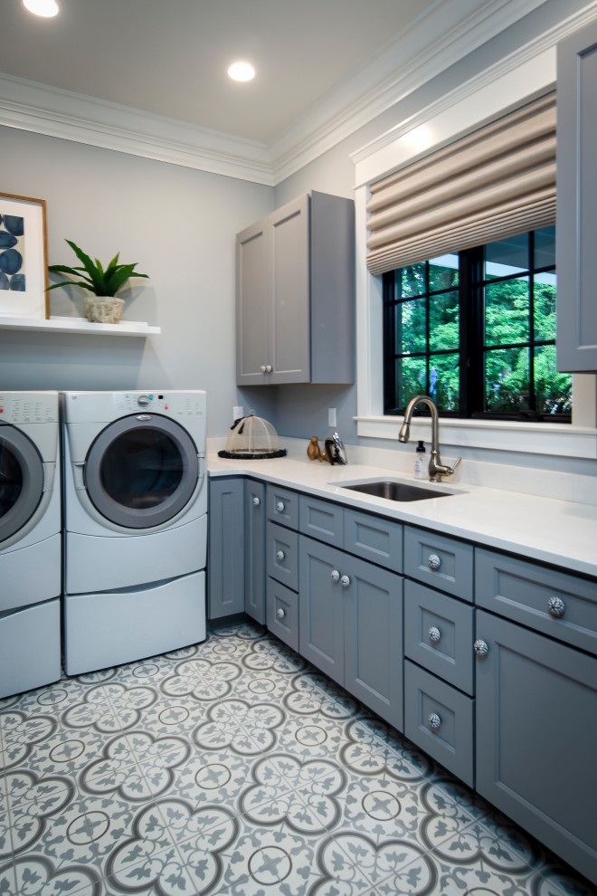 Inspiration for a large transitional l-shaped ceramic tile and multicolored floor dedicated laundry room remodel in Dallas with an undermount sink, recessed-panel cabinets, gray cabinets, quartz countertops, gray walls, a side-by-side washer/dryer and white countertops