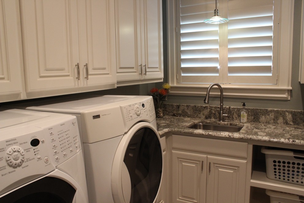 Example of a mid-sized classic u-shaped dedicated laundry room design in Austin with an undermount sink, raised-panel cabinets, white cabinets, granite countertops, gray walls and a side-by-side washer/dryer