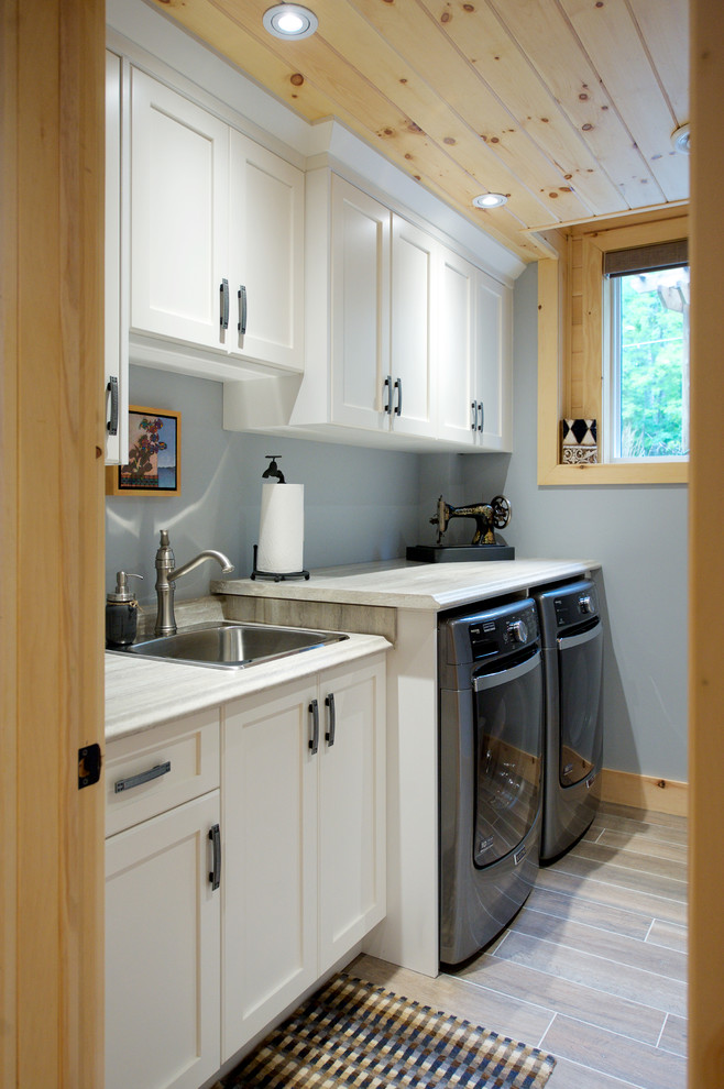 Inspiration for a medium sized nautical single-wall utility room with a built-in sink, shaker cabinets, white cabinets, grey walls and medium hardwood flooring.