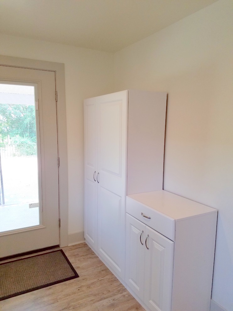 Design ideas for a small classic single-wall utility room in Other with white cabinets, vinyl flooring, raised-panel cabinets and a side by side washer and dryer.