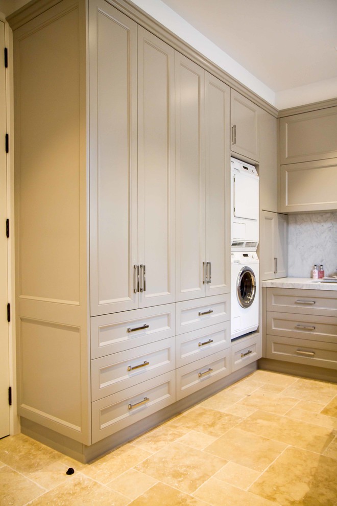 Large traditional u-shaped utility room in Melbourne with shaker cabinets, marble worktops and a stacked washer and dryer.