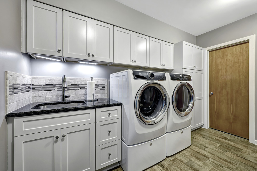 Inspiration for a medium sized classic single-wall separated utility room in Charleston with a single-bowl sink, shaker cabinets, white cabinets, granite worktops, grey walls, porcelain flooring, a side by side washer and dryer and beige floors.