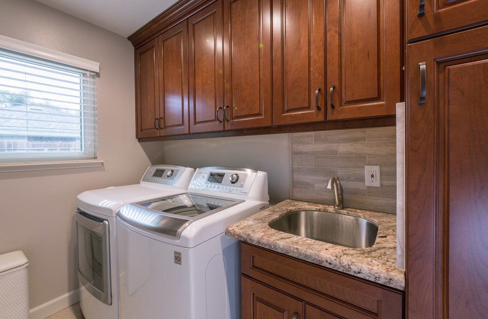 Example of a small transitional galley dedicated laundry room design in Sacramento with a drop-in sink, flat-panel cabinets, medium tone wood cabinets, granite countertops, gray walls and a side-by-side washer/dryer