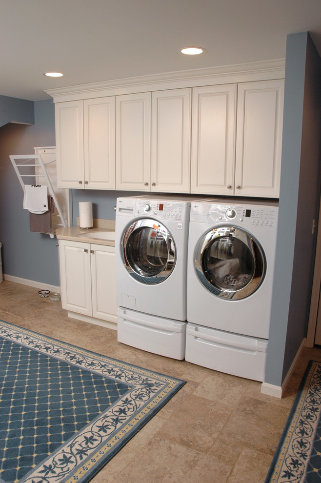 Exempel på ett mellanstort klassiskt grovkök, med vita skåp, blå väggar, klinkergolv i porslin, en tvättmaskin och torktumlare bredvid varandra och en undermonterad diskho