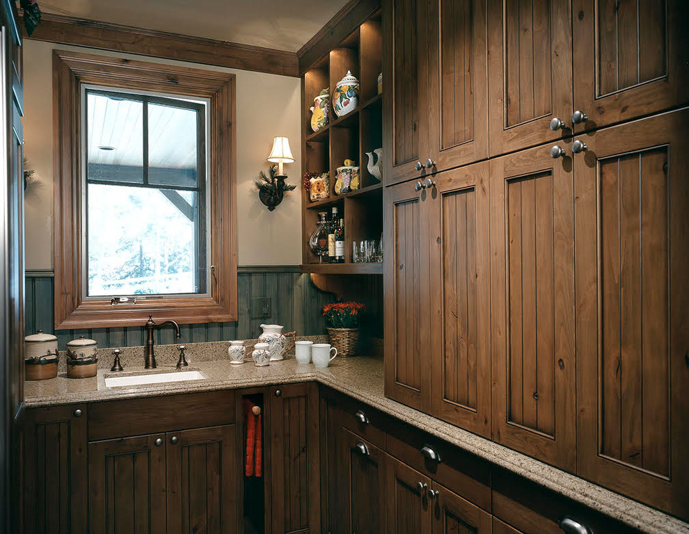 Inspiration for a mid-sized rustic u-shaped utility room remodel in Denver with an undermount sink, recessed-panel cabinets, dark wood cabinets, granite countertops, beige walls and multicolored countertops