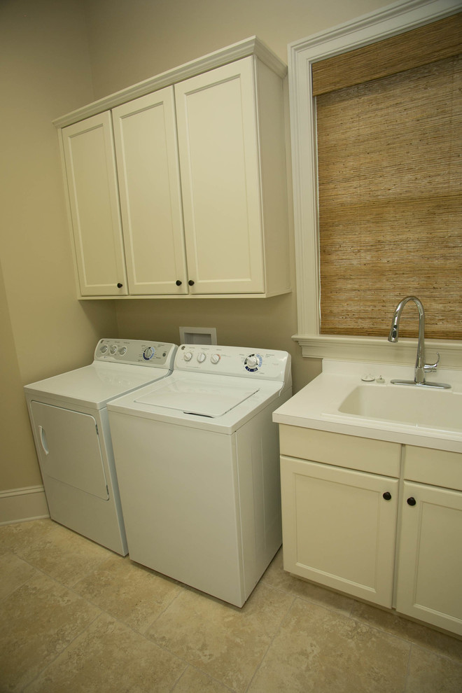 Bild på en mellanstor vintage parallell tvättstuga enbart för tvätt, med luckor med infälld panel, vita skåp, en tvättmaskin och torktumlare bredvid varandra och en nedsänkt diskho