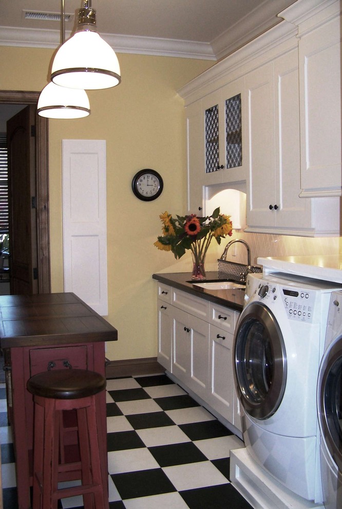 Design ideas for a classic utility room in San Diego with composite countertops, white cabinets, multi-coloured floors and black worktops.