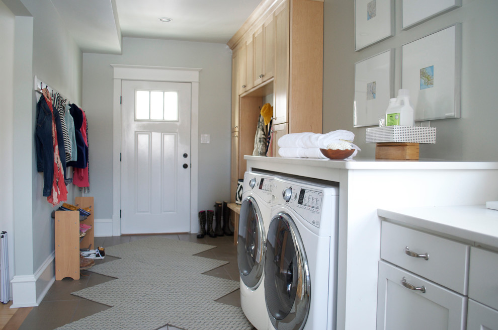 Esempio di una grande lavanderia multiuso tradizionale con pavimento con piastrelle in ceramica, ante in stile shaker, ante in legno chiaro, pareti bianche e lavatrice e asciugatrice affiancate