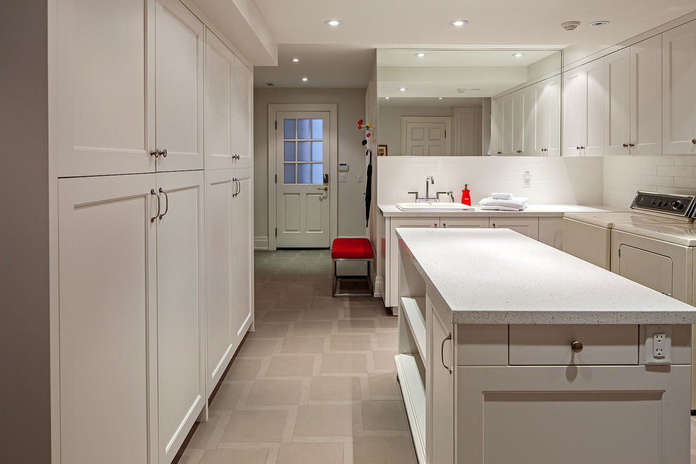 Klassischer Hauswirtschaftsraum mit weißen Schränken, grauem Boden und weißer Arbeitsplatte in Toronto