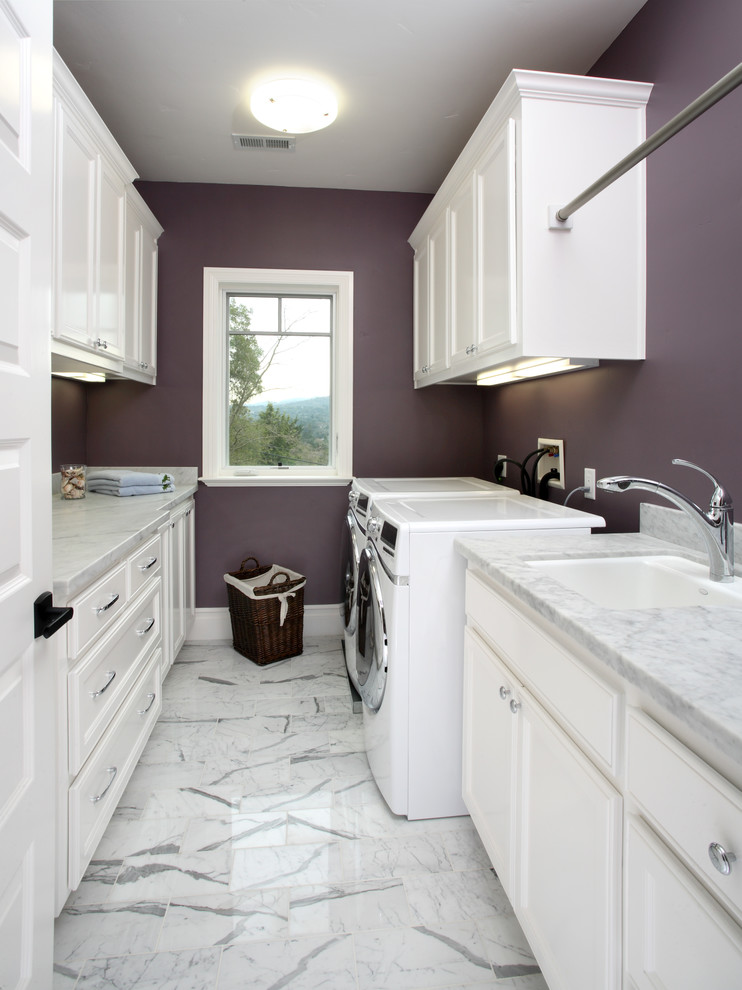 Bild på en vintage tvättstuga, med lila väggar, vita skåp och vitt golv