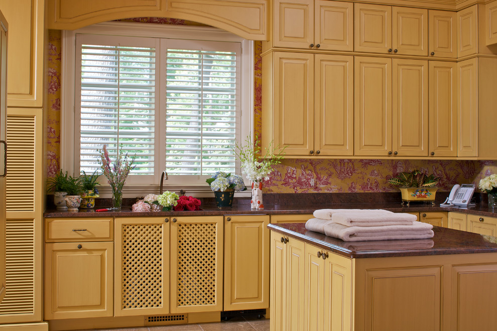 Klassischer Hauswirtschaftsraum in L-Form mit profilierten Schrankfronten, gelben Schränken und bunten Wänden in Sonstige