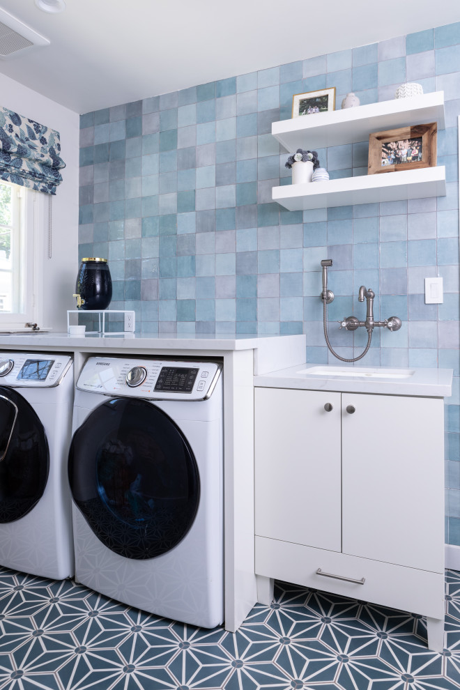 Idéer för en mellanstor klassisk vita l-formad tvättstuga, med en undermonterad diskho, skåp i shakerstil, vita skåp, bänkskiva i kvarts, betonggolv, en tvättmaskin och torktumlare bredvid varandra och blått golv