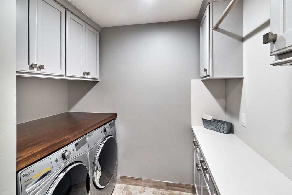 Design ideas for a small classic galley separated utility room in San Francisco with grey cabinets, grey walls, porcelain flooring, a side by side washer and dryer, grey floors, recessed-panel cabinets and wood worktops.
