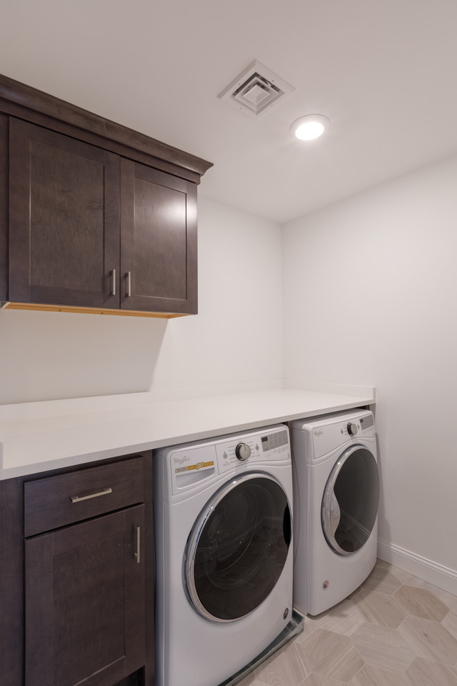 Kleine Klassische Waschküche mit flächenbündigen Schrankfronten, dunklen Holzschränken, weißer Wandfarbe und Waschmaschine und Trockner nebeneinander in Sonstige