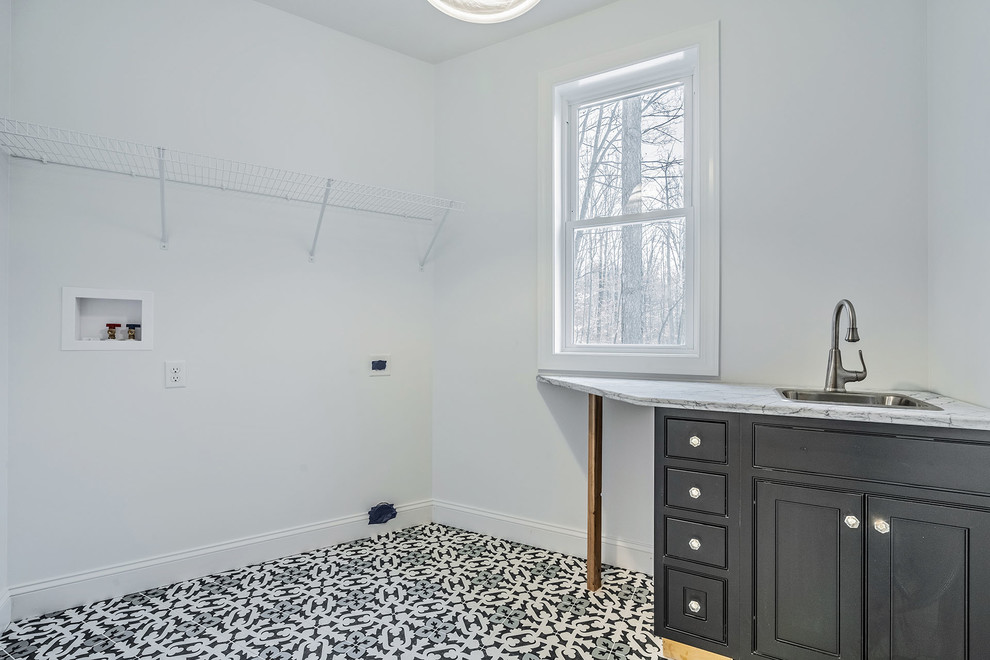 Large transitional single-wall ceramic tile and multicolored floor dedicated laundry room photo in New York with an undermount sink, shaker cabinets, black cabinets, quartz countertops, beige walls, a side-by-side washer/dryer and multicolored countertops