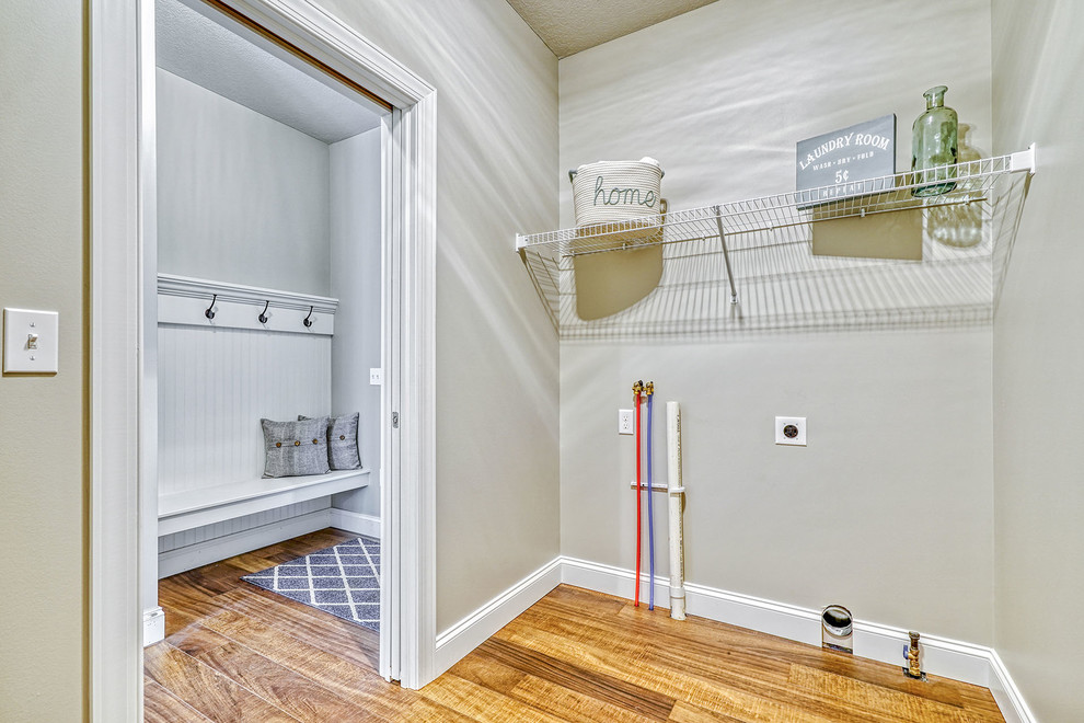 Idéer för stora vintage parallella tvättstugor enbart för tvätt, med grå väggar, mellanmörkt trägolv, en tvättmaskin och torktumlare bredvid varandra och flerfärgat golv