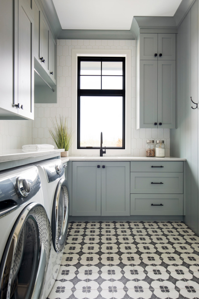 Example of a large country l-shaped ceramic tile, multicolored floor and wall paneling dedicated laundry room design in Minneapolis with a drop-in sink, gray cabinets, quartz countertops, white backsplash, ceramic backsplash, white walls, a side-by-side washer/dryer and white countertops