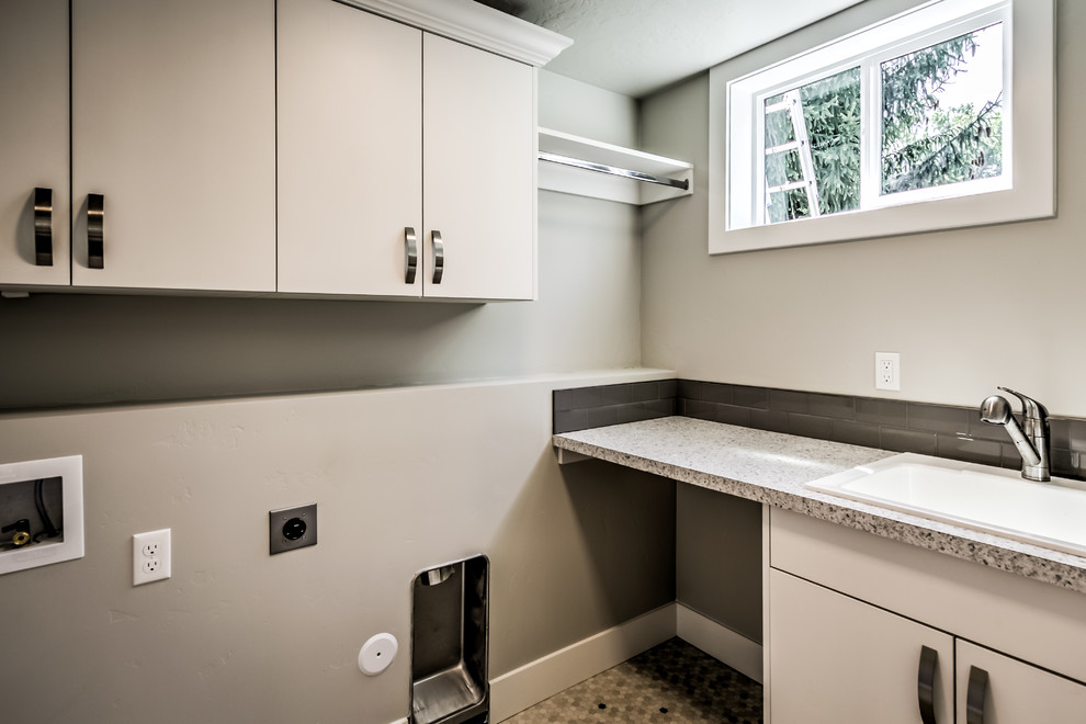 Idee per una sala lavanderia tradizionale di medie dimensioni con lavello da incasso, ante lisce, ante bianche, pareti grigie, pavimento multicolore e top grigio