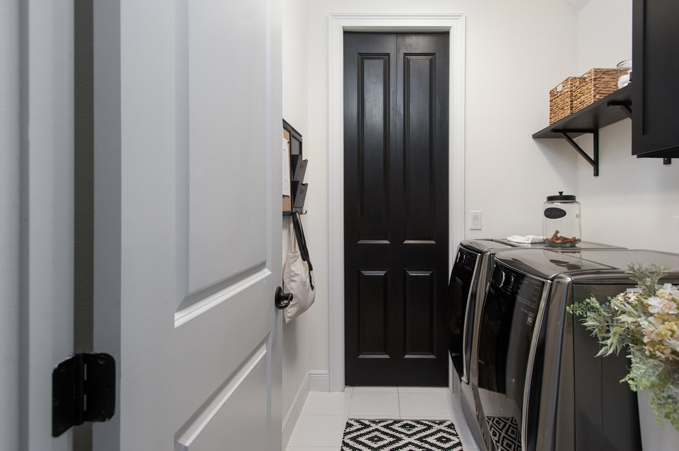 Idee per un ripostiglio-lavanderia classico di medie dimensioni con ante in stile shaker, ante nere, pareti bianche, lavatrice e asciugatrice affiancate e pavimento bianco