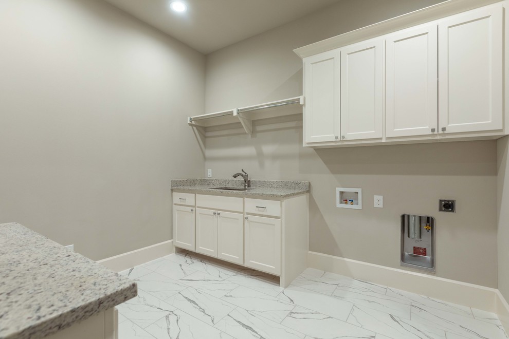 Inspiration for a large traditional galley separated utility room in Dallas with a submerged sink, raised-panel cabinets, white cabinets, granite worktops, grey walls, porcelain flooring, a side by side washer and dryer, white floors and grey worktops.